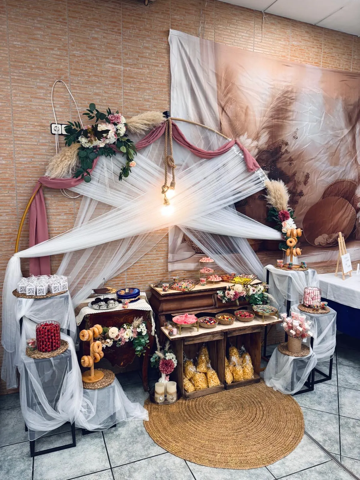 Candy bar con arco de flores y chucherías