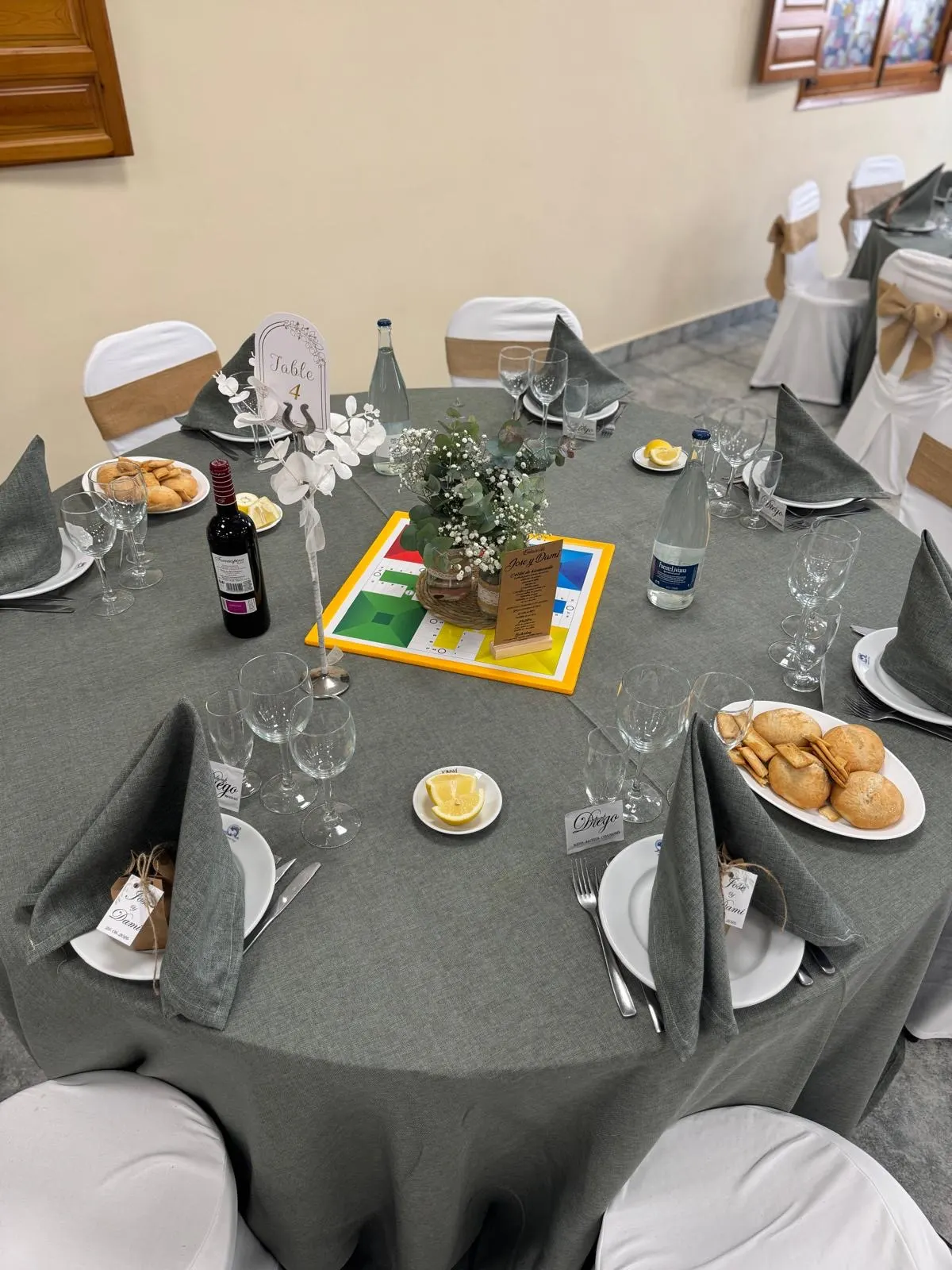 Mesa redonda con mantel verde y centro personalizado